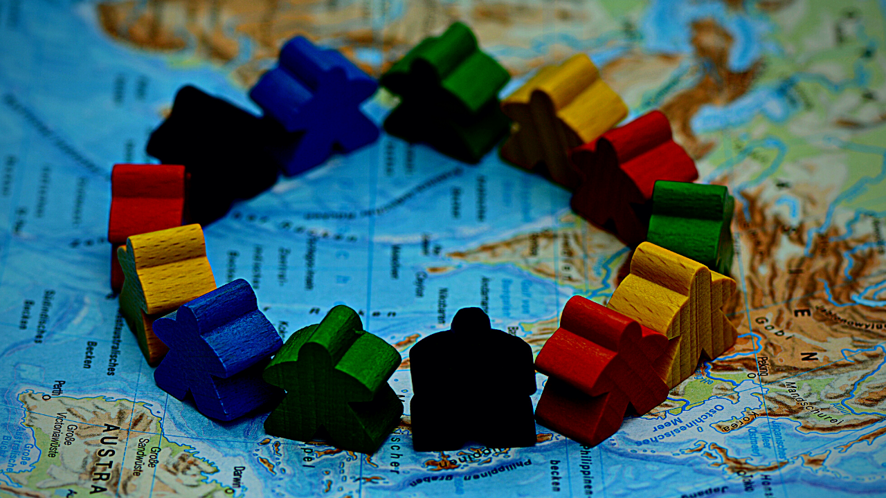 Various colored wooden game pieces stand together on a map.