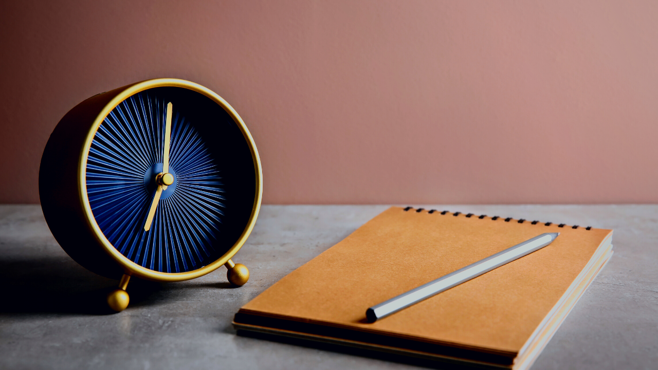 A clock, a notepad, and a pencil.