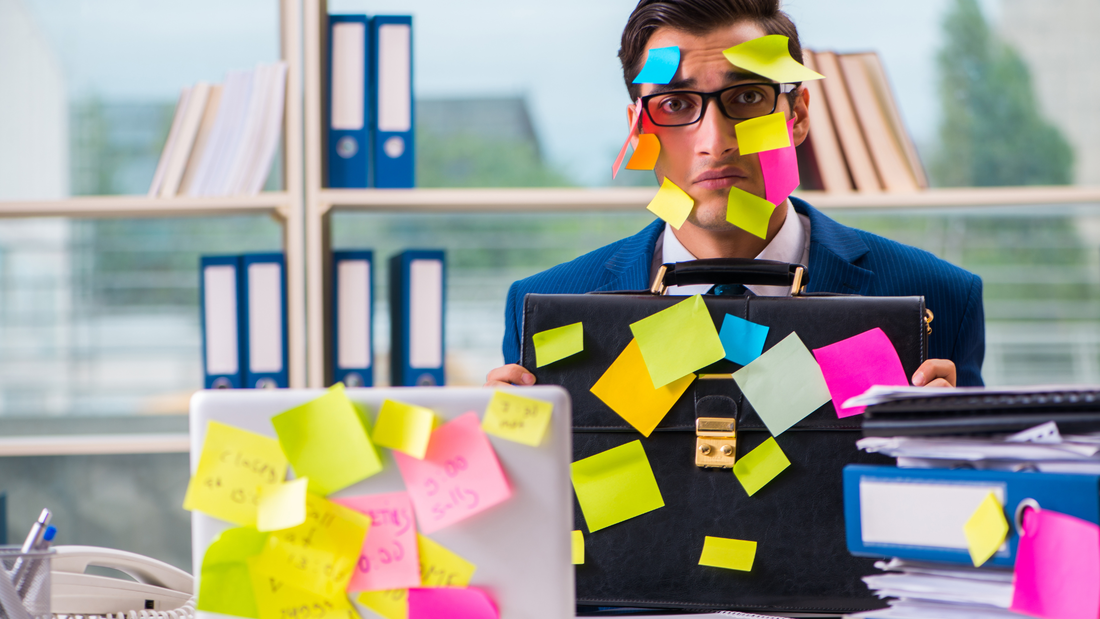A business person covered in Post-It notes.