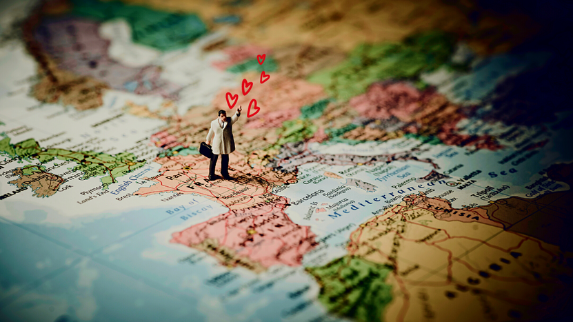 A person seeks direction with heart atop a map of Europe.